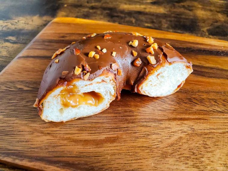 半分にカットしたファミリーマートもっちり食感キャラメルドーナツが板の上にのっている