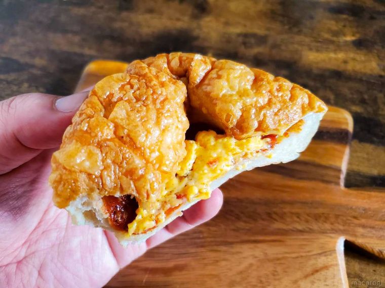 半分にカットしたファミリーマートもっちり食感ピザパンを手で割っている様子