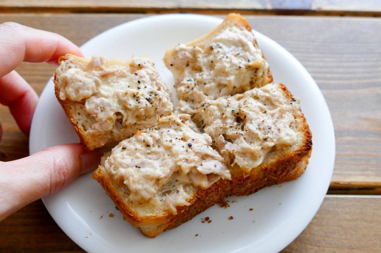 カットしたツナマヨ食パンを手でつまむ様子