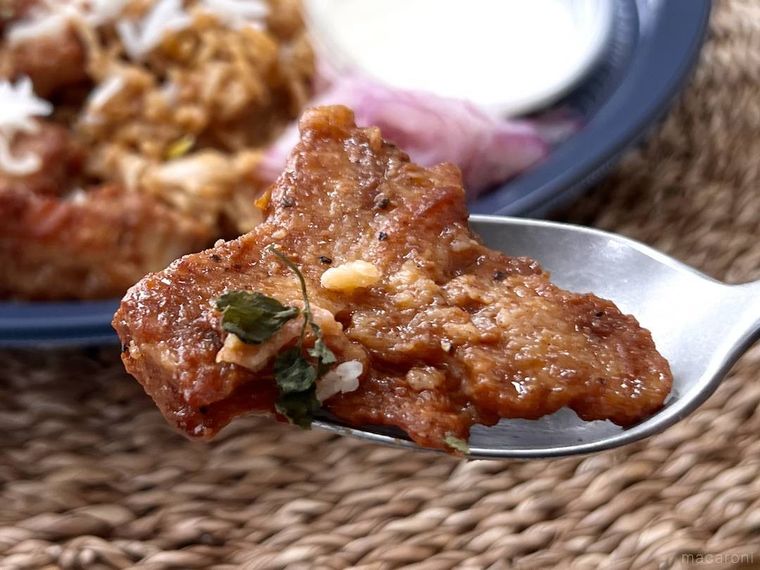 たんぱく質が摂れるチキンビリヤニのチキンをスプーンですくった様子