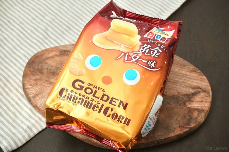 木のカッティングボードにのった黄金バター味のキャラメルコーンのパッケージ