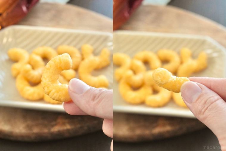 白い小皿にのった黄金バター味のキャラメルコーンを手に持つ様子