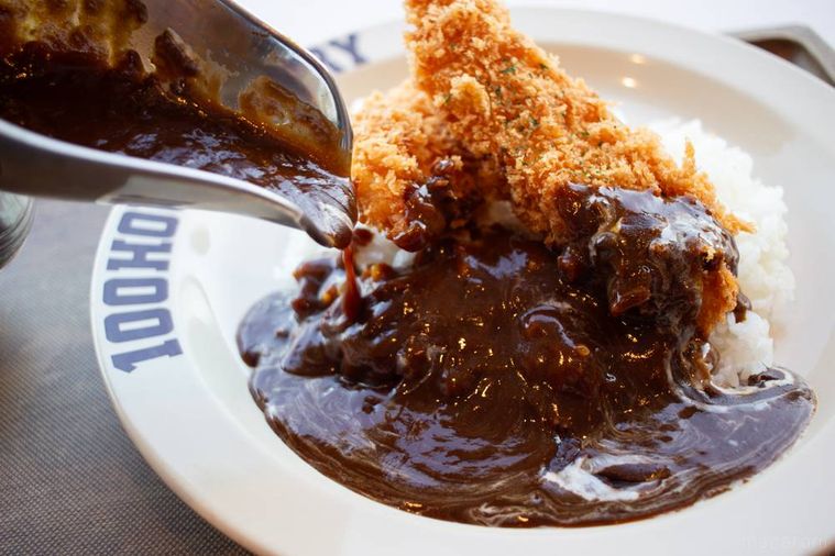 100時間カレーしっとり手仕込みささみカツカレーにスパイシービーフカレーをかけている様子