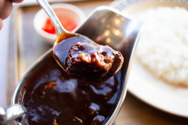 100時間カレー和牛カレーのルーに入った和牛をスプーンで箸上げしている様子
