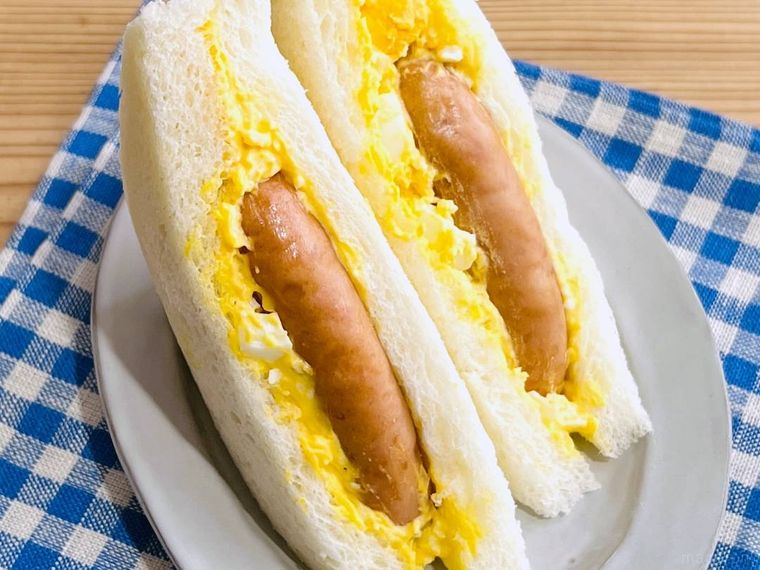 コンビニのたまごサンドに、丸大食品の燻製屋熟成あらびきポークウインナーを挟んだ様子