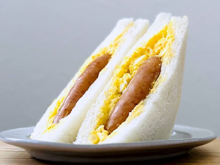 コンビニのたまごサンドに、丸大食品の燻製屋熟成あらびきポークウインナーを挟んだ様子