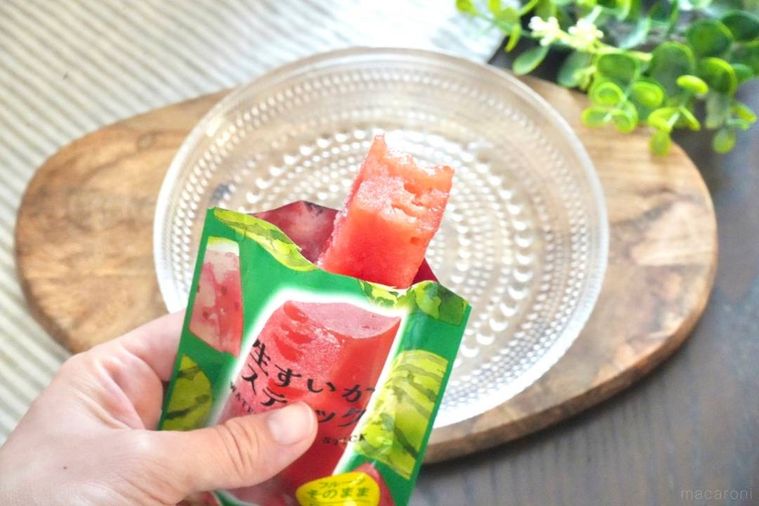 ガラスの器と冷凍すいかスティックを手に持つ様子