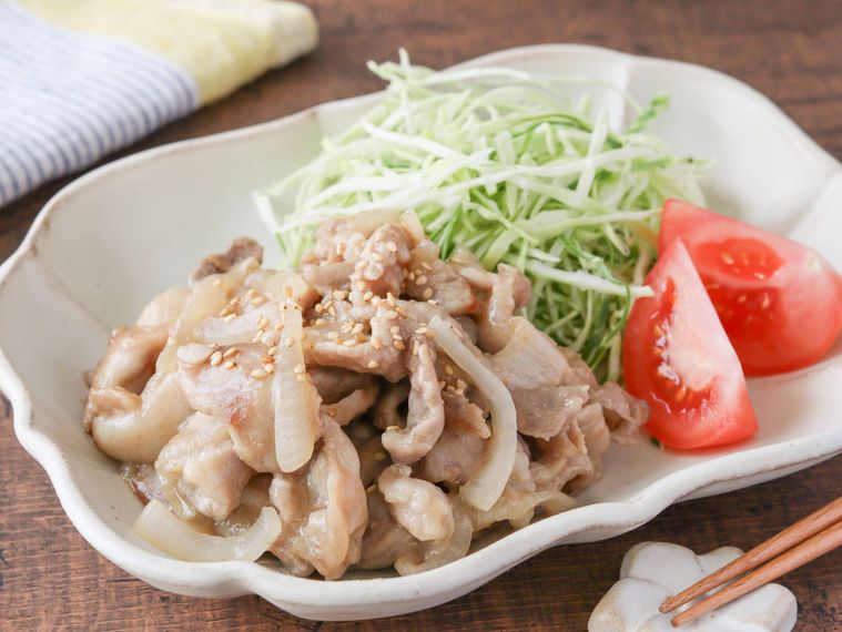 器に盛り付けられた千切りキャベツ、トマト、味噌の生姜焼き