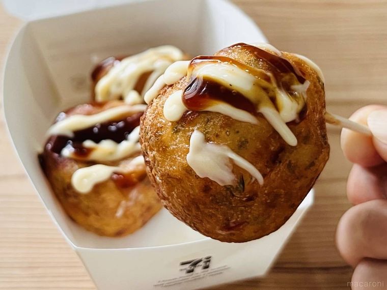 セブンイレブンの揚げたこ焼きを爪楊枝で持ち上げている様子