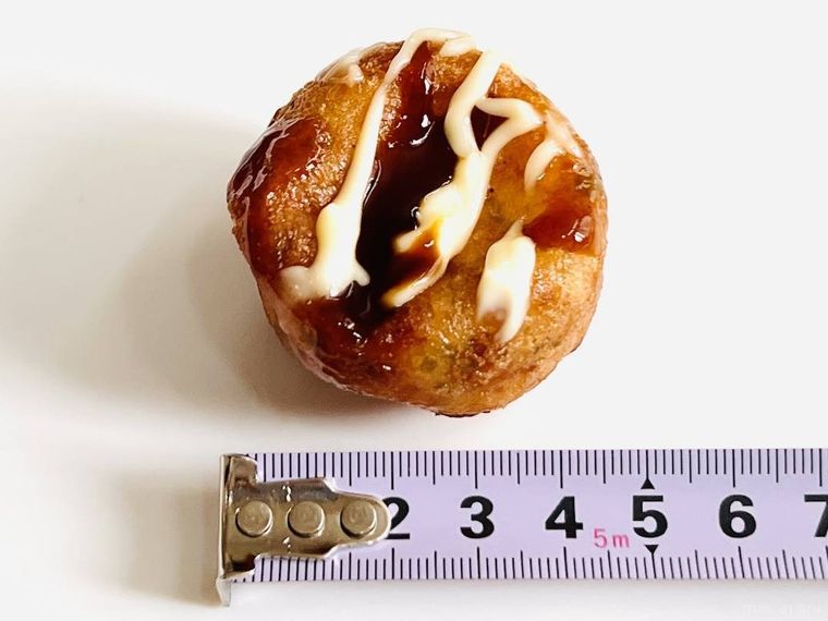 セブンイレブンの揚げたこ焼きの大きさをメジャーで測っている様子