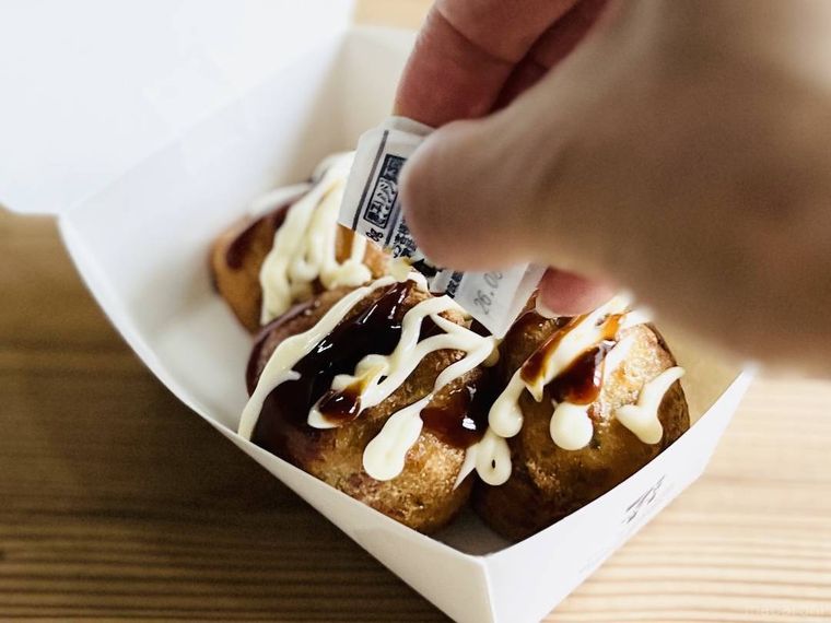 セブンイレブンの揚げたこ焼き 3個入りにマヨソースをかけている様子