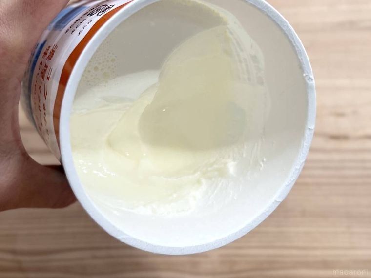 成城石井のジャージー生乳を使ったグリークヨーグルトの容器を傾けている様子