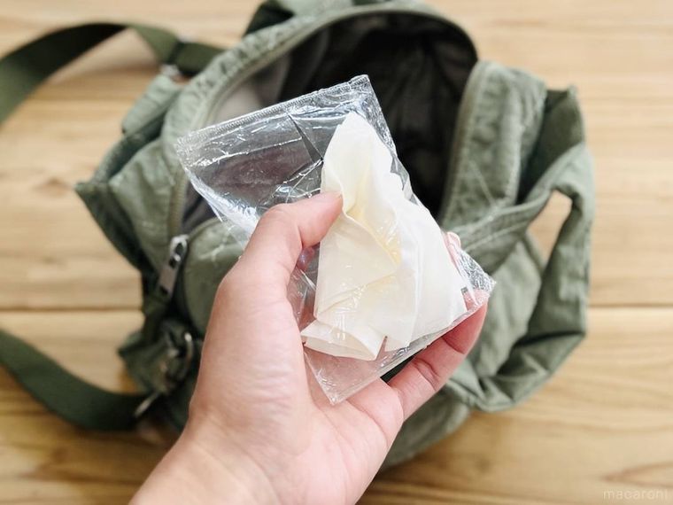 くしゃくしゃになったポケットティッシュとカーキのバッグ