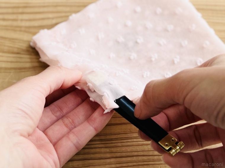 ピンク色の巾着にバネ口金を通している様子