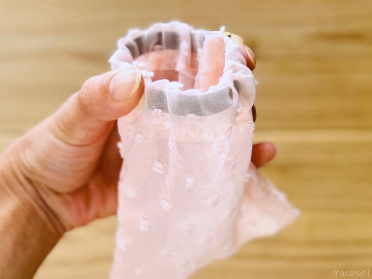 ピンク色のバネ口ポーチを手で開けた様子