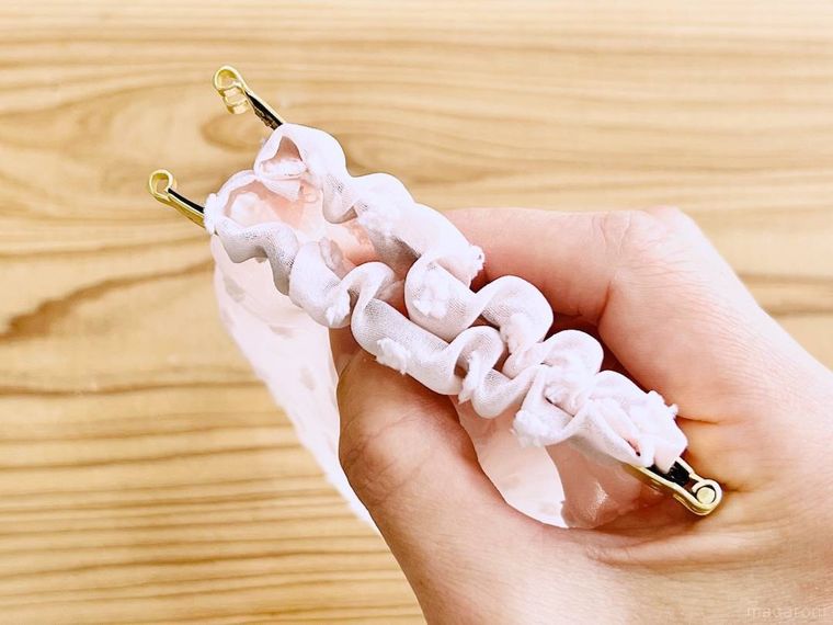 ピンク色の巾着にバネ口金を通した様子