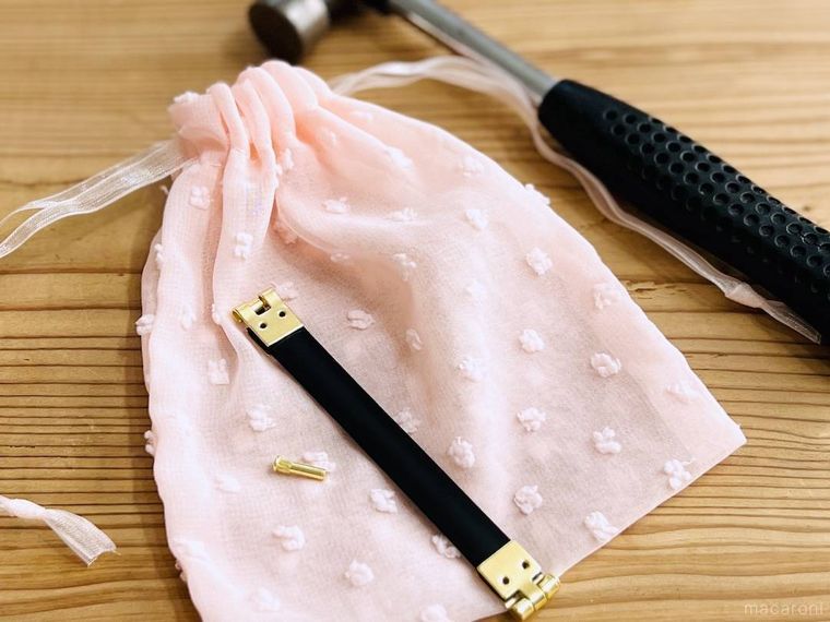 ピンク色の巾着、バネ口金、ネジ、かなづち