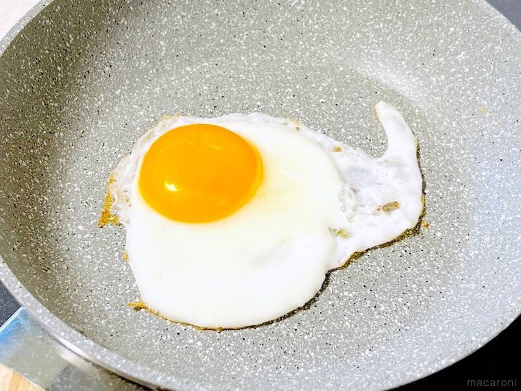 フライパンで目玉焼きを焼いている様子