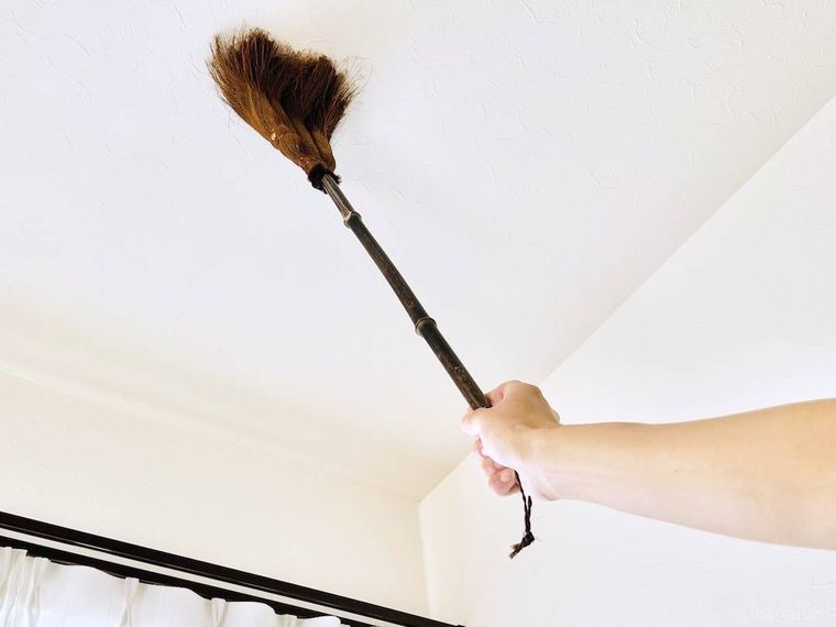 天井をほうきで掃除している様子
