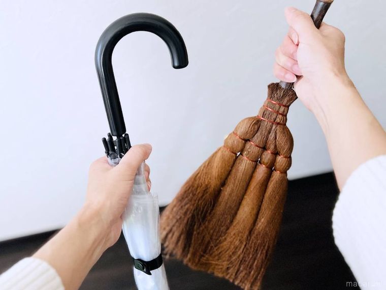 傘とほうきを両手で持っている様子