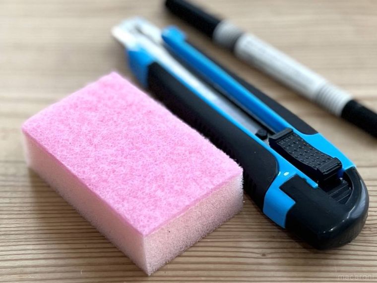 ピンク色の食器用スポンジ、カッター、油性ペンが並んでいる様子
