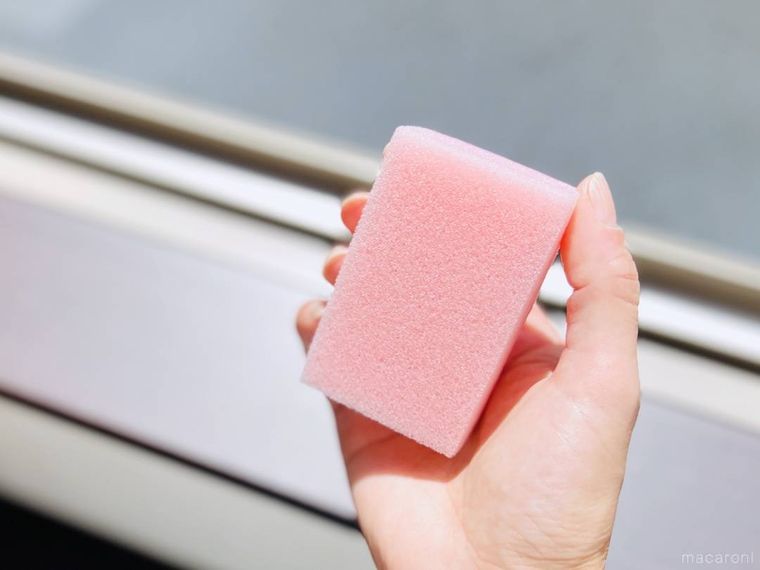 ピンク色の食器用スポンジを手で持っている様子
