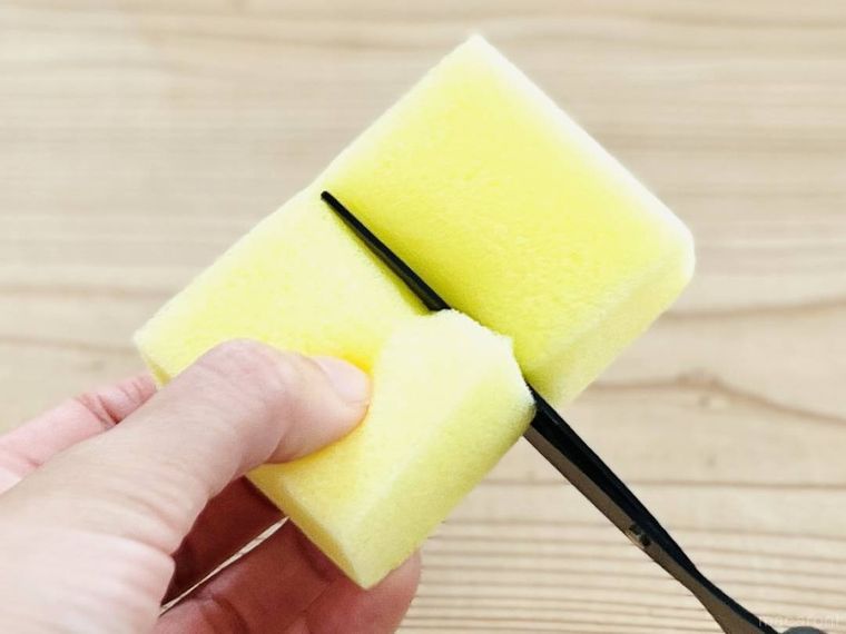食器用スポンジをハサミで切っている様子