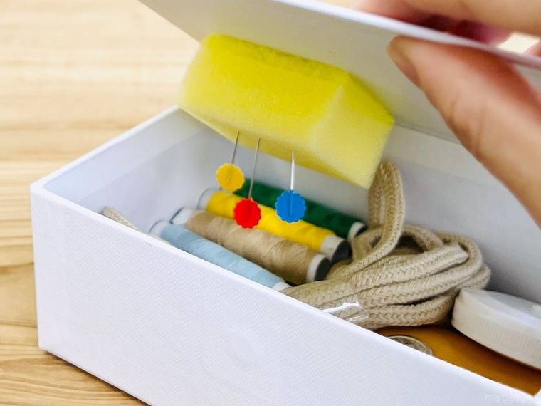 裁縫道具が入ったケースのフタを閉めている様子