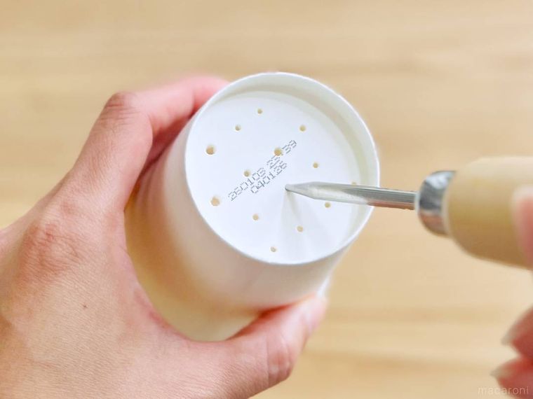 紙コップの底にアイスピックで穴を開けている様子