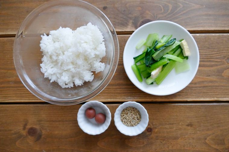 カリカリ梅と小松菜煮浸しの混ぜご飯の材料が並ぶ木製テーブル