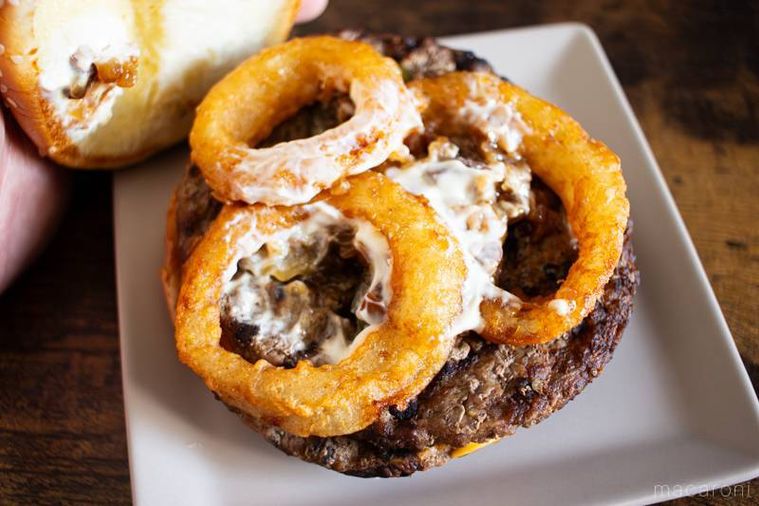 バーガーキングオニオンリングダブルビーフ ビッグマウス スモークハウスのバンズを持ち上げて具材を見せている様子