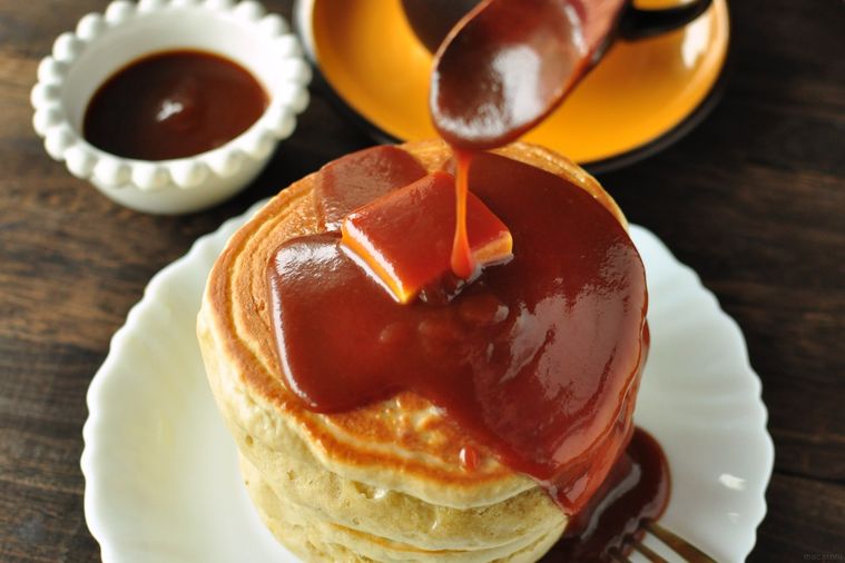 ホットケーキにキャラメルソースをかける様子