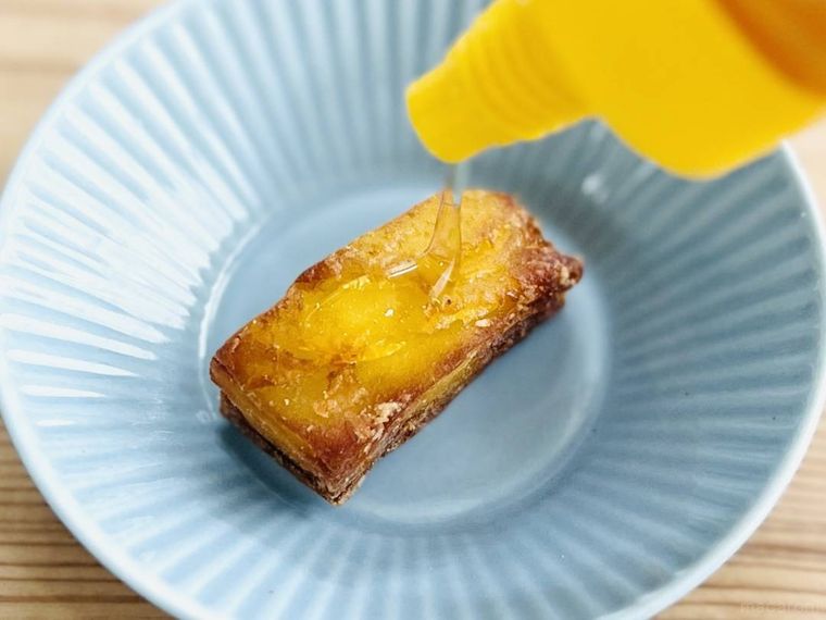 ローソンのミルフィーユポテト さつまいもにはちみつをかけている様子