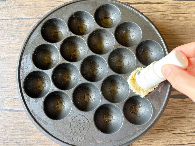 たこ焼き器に油をひく様子