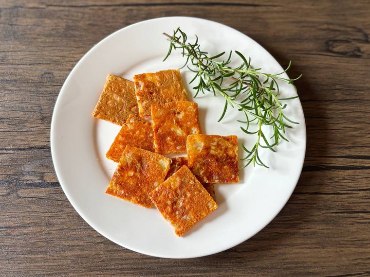 白色の皿に盛られたとろけるチーズのカリカリ焼き