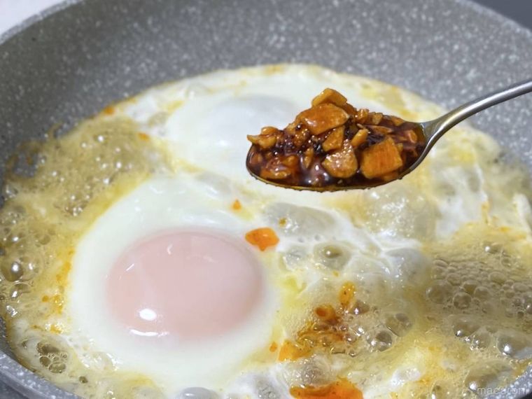 食べるラー油をホットハニーエッグにかけようとしている様子