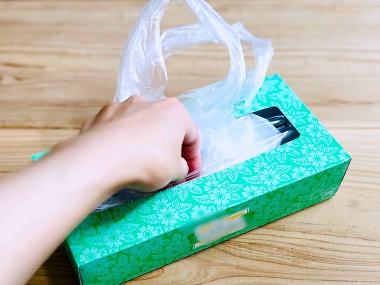 ティッシュの空き箱にポリ袋を詰めている様子