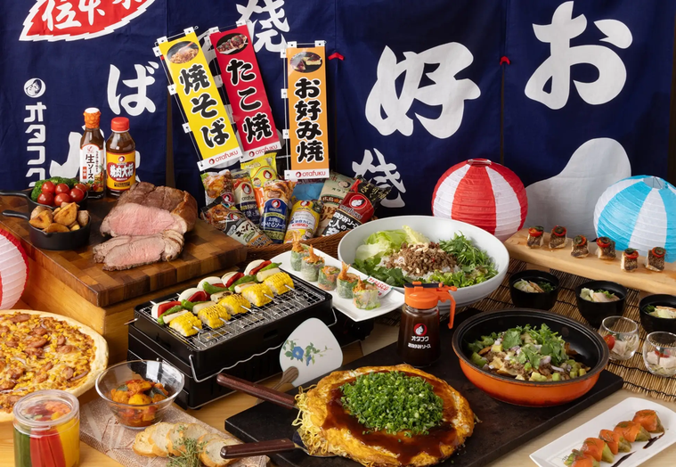 お好み焼きののれんの前に並ぶお好み焼きやサラダ、ローストビーフなど