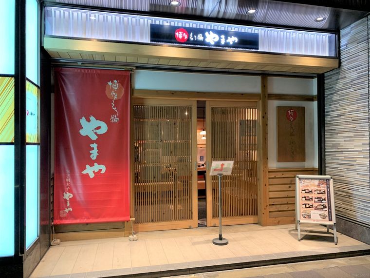 木の引き戸と白壁が上品な博多もつ鍋やまや エキマルシェ大阪店外観