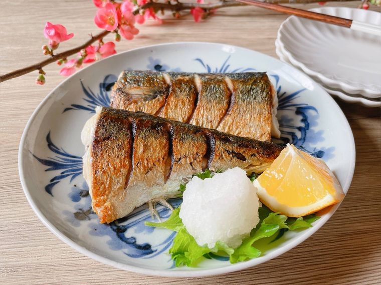 丸い和皿に盛られた塩さば、大根おろし、レモン、取り皿、箸