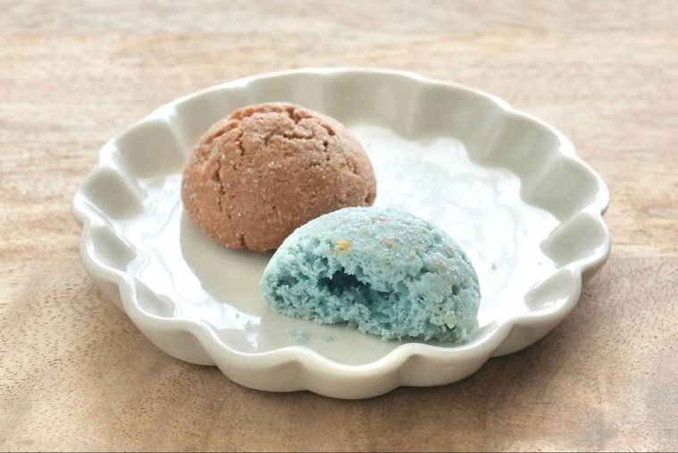 木のカッティングボードと白い小皿にのったチョコミント味のココナッツマカロン