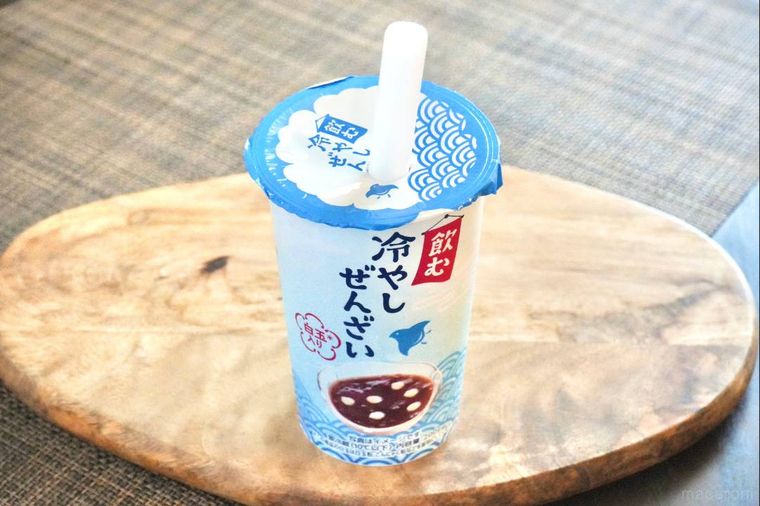 木のカッティングボードにのった水色のパッケージの冷やしぜんざいドリンク