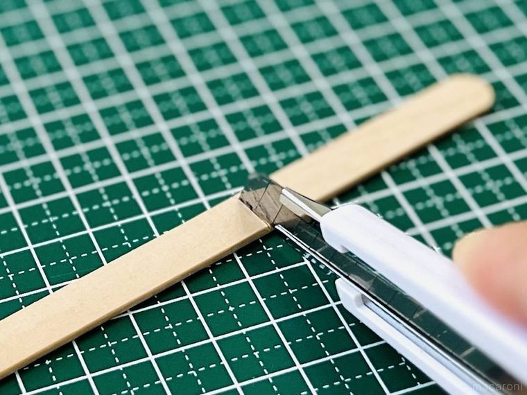 アイスの棒にカッターで切り込みを入れている様子