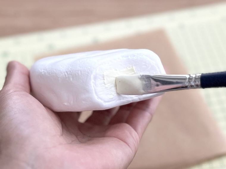 粘土に白い絵の具を塗っている様子