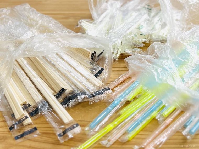 テーブルの上に割り箸、ストロー、プラスチックカトラリーが置かれている様子