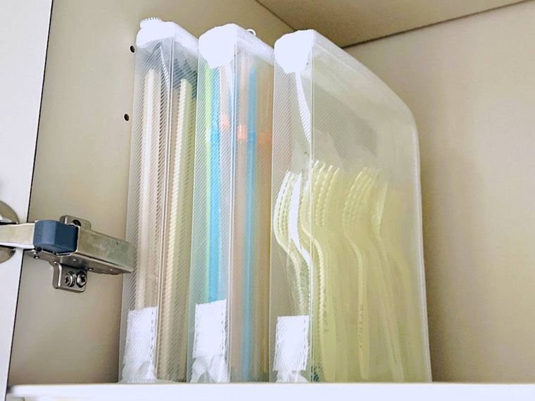 割り箸、ストロー、プラスチックカトラリーが入ったファスナーケースを棚に収納した様子