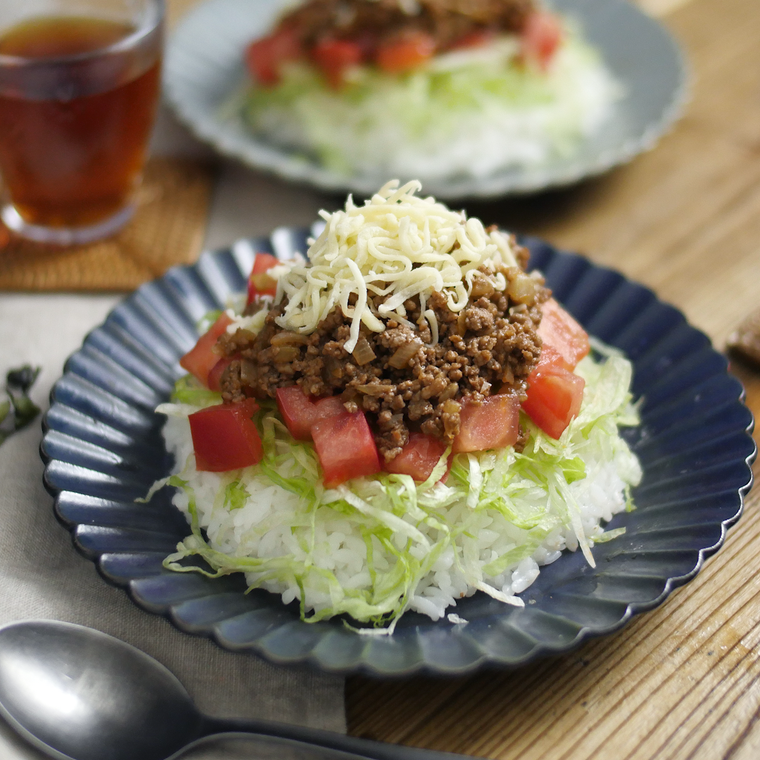 タコライスが盛られている皿がふたつある食卓