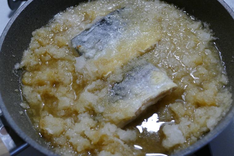 フライパンに調味料、水、大根おろしを加えて煮る様子