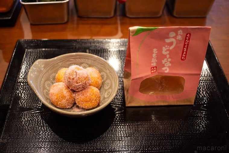 お皿に盛り付けた丸亀製麺丸亀うどーなつ もも風味とパッケージ