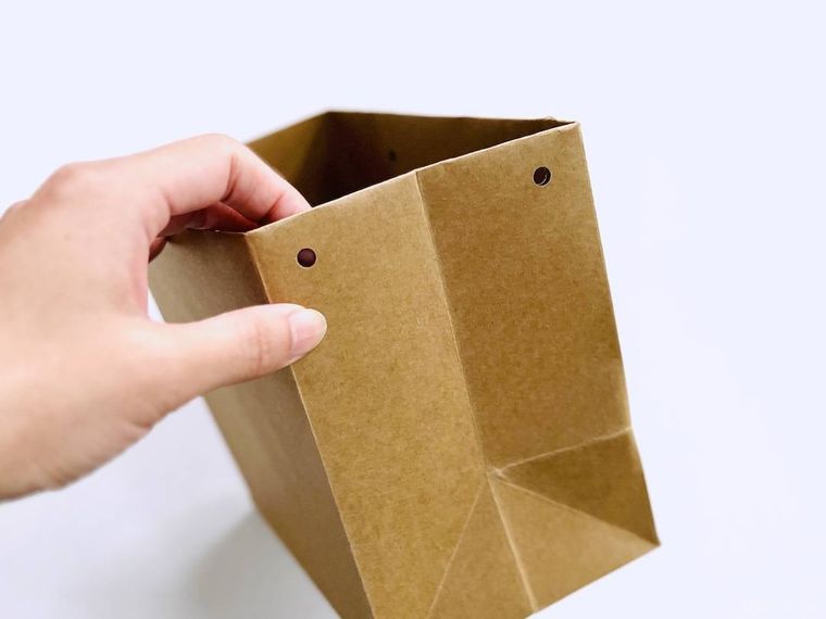 紙袋の側面に穴をふたつ開けた様子